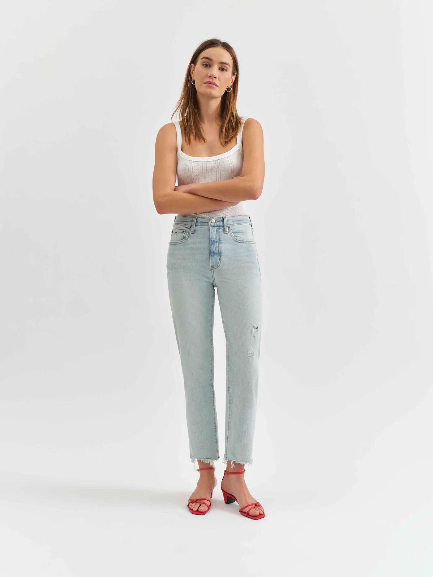 Model wearing the Straight Up High Rise Jeans in Swoon Vintage, paired with a white tank and red strappy heels.