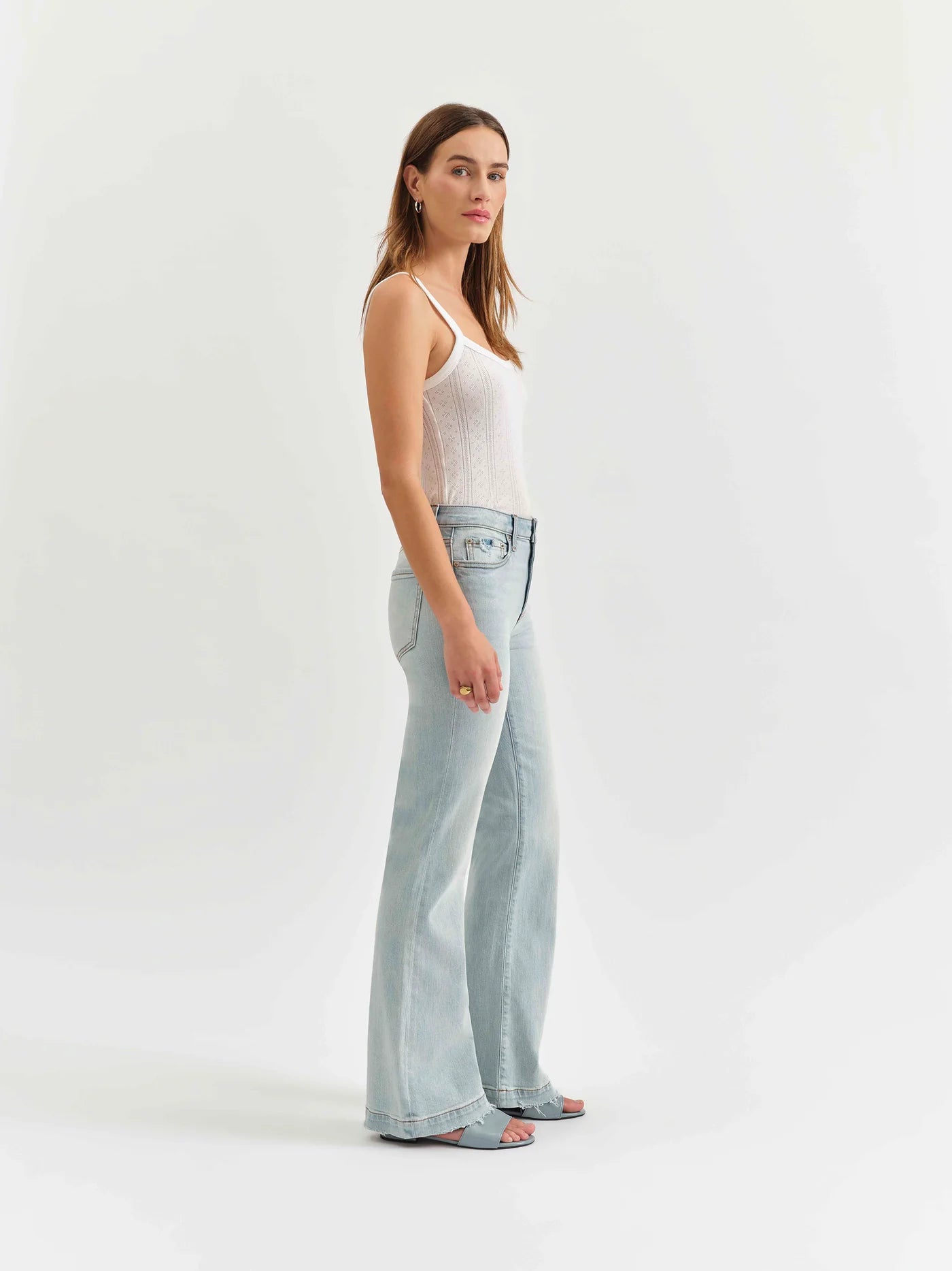 Side view of a model wearing the mid-rise flare jeans by Daze Denim in swoon vintage wash.