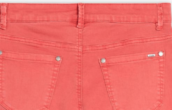 Close-up of back waistband and pockets on coral cropped jeans by Lois.