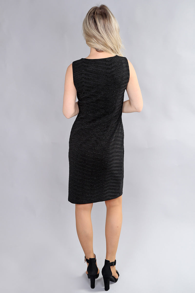 Back view of a model wearing the black sleeveless dress by Michael Tyler.