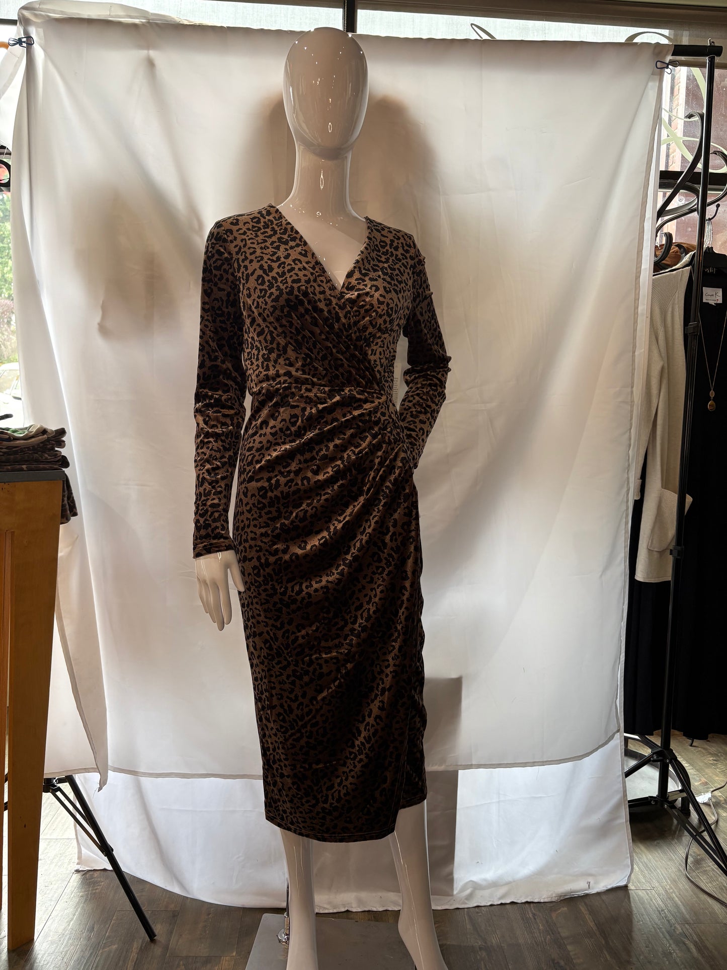 Full view of a mannequin wearing Angeleye's leopard wrap dress.