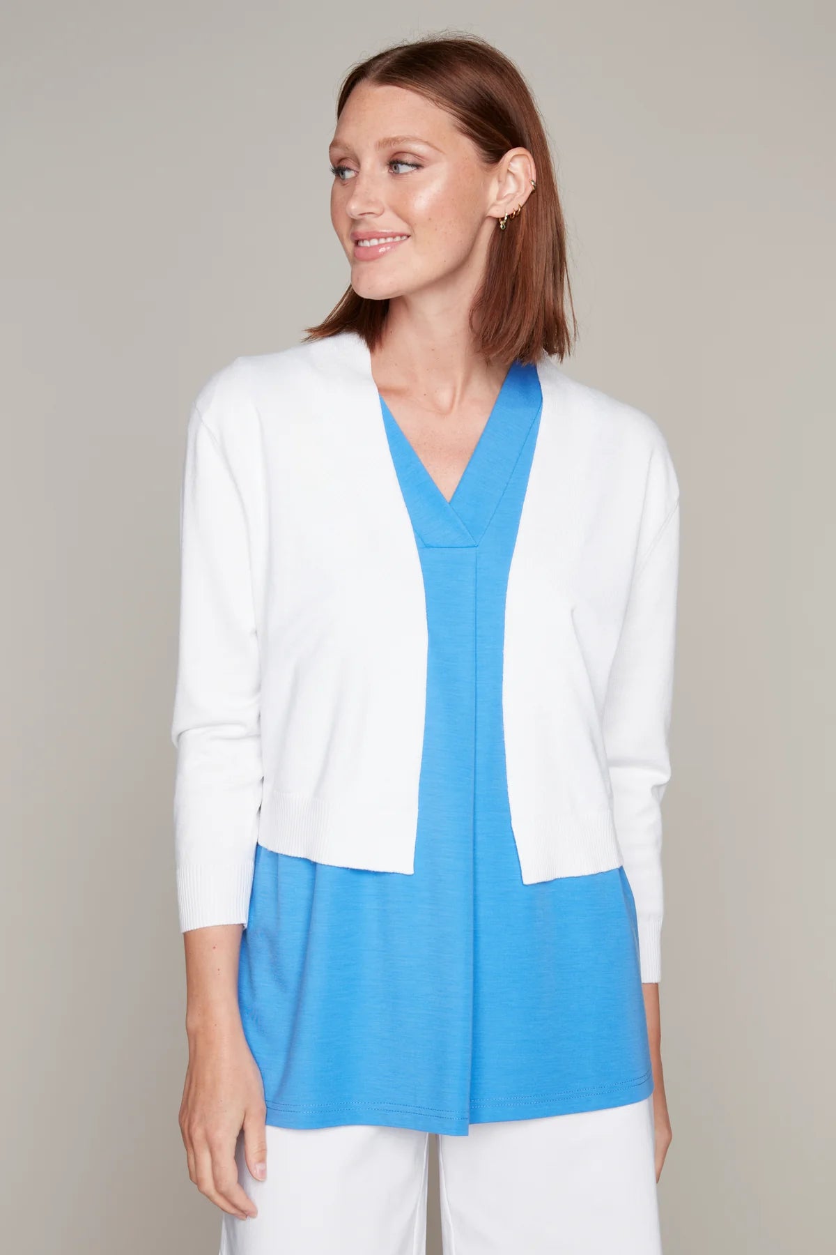 Model wearing Carre Noir's white knit bolero cardigan with 3/4 sleeves.