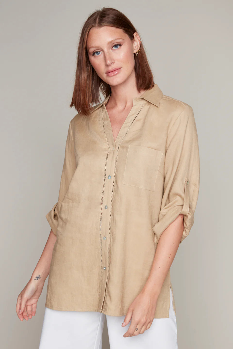 Model wearing Carré Noir's tan linen button-up blouse with pintuck detail.