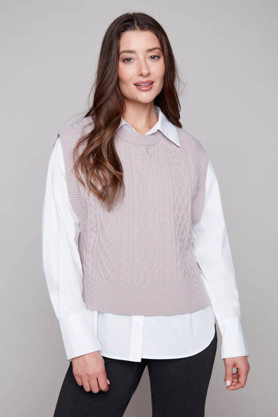 Model wearing a light taupe cable knit sweater vest from Carre Noir.