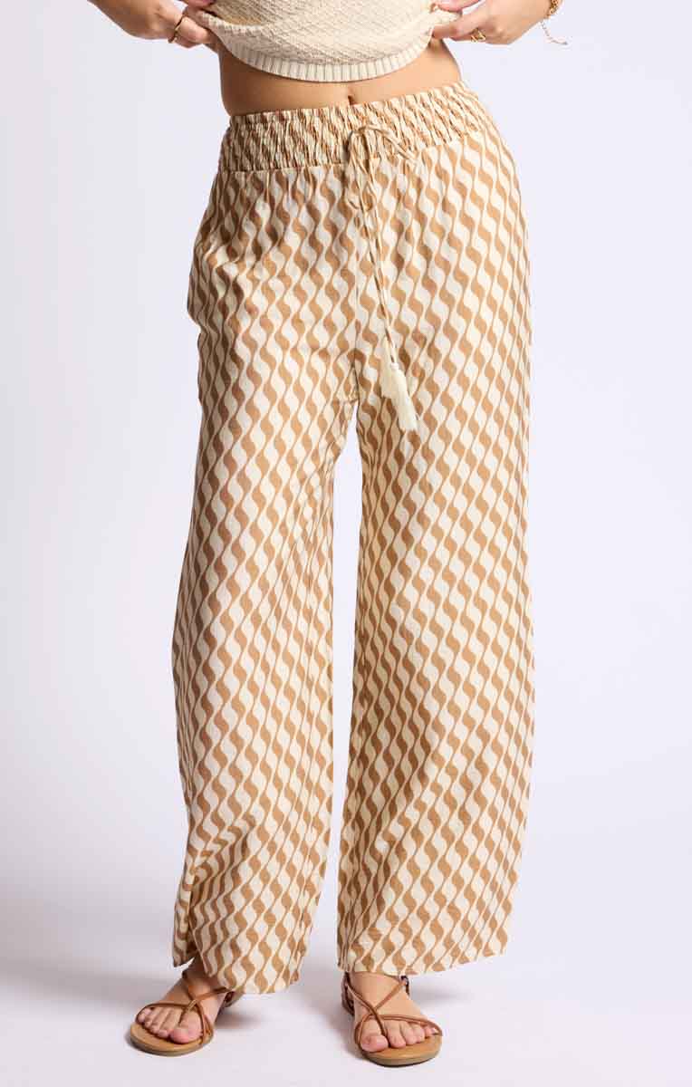 Close-up view of the lightweight patterned palazzo pants in tan. Sage the Label's palazzo pants have a relaxed, flowy fit.