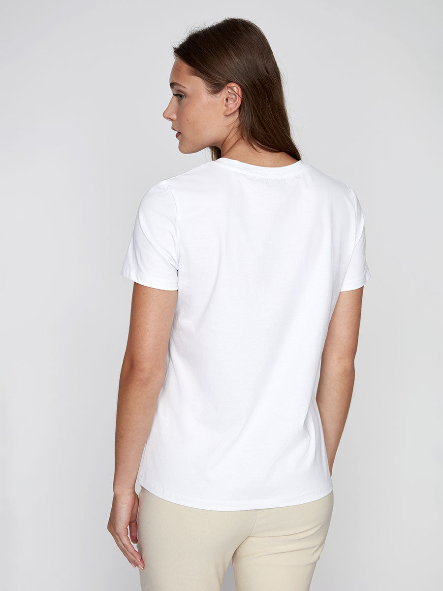 Back view of a model wearing CYC white floral graphic tee with navy and gold metallic heart design.
