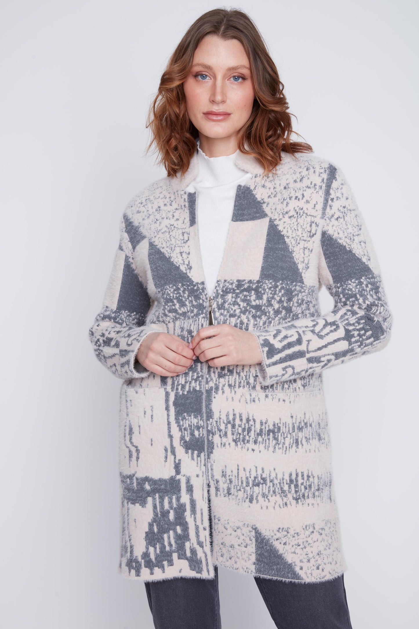 Model wearing CYC's cream and grey knit zip jacket with front pockets, styled open over a white top.