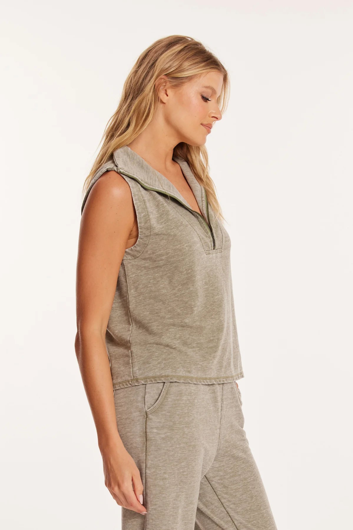 Side view of a model wearing Mododoc 1/4 zip-front vest in the colour Faded Fennel.