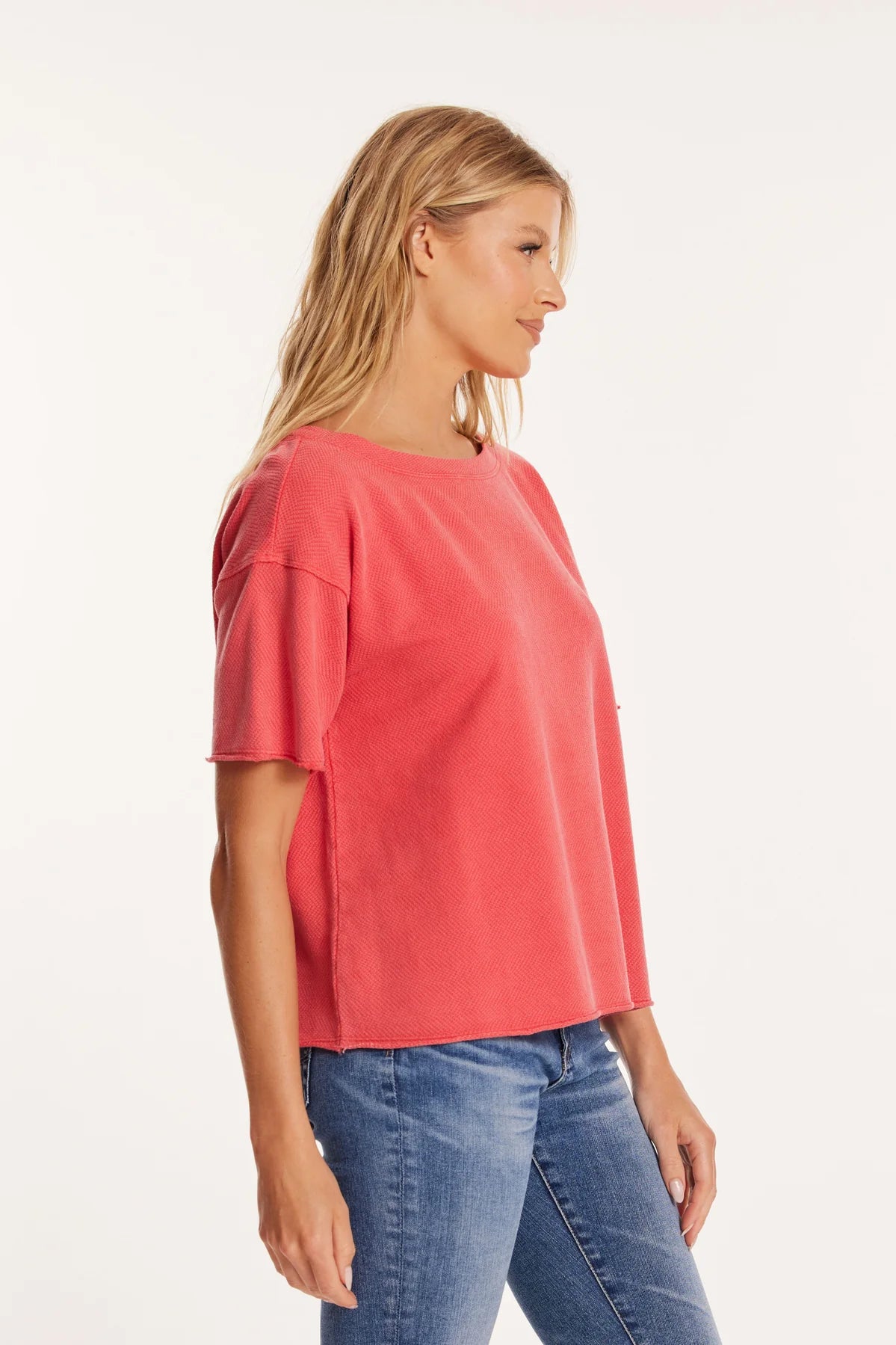 Side profile of the oversized Mododoc tee highlights the tee’s easy drape and slightly curved hem. The structured knit texture adds dimension to the otherwise simple shape.
