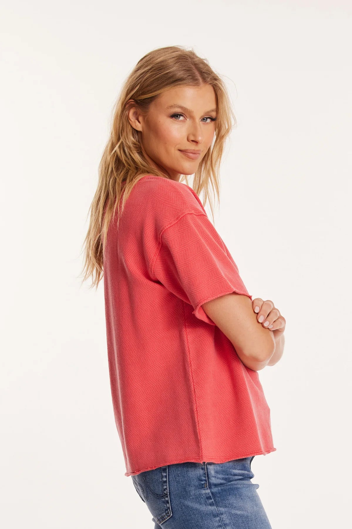 The model turns slightly to showcase the boxy cut of the tee and its roomy, unstructured style. The boatneck neckline lies flat for a polished look while maintaining laid-back appeal.