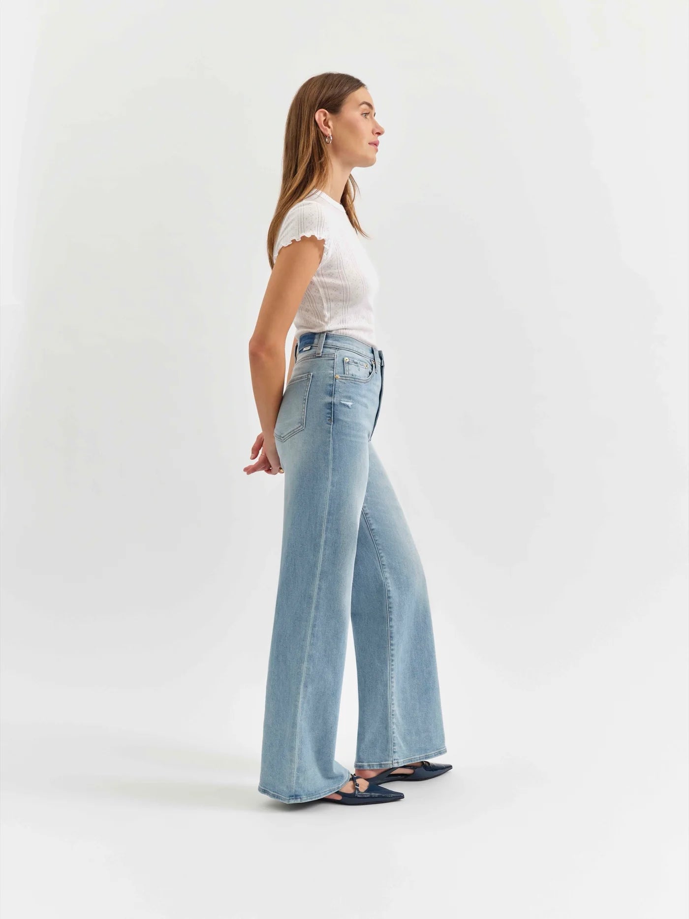 Side view of the Daze Far Out High Rise Wide Leg Jeans in Blooming Vintage. The high-rise waist and wide-leg cut elongate the legs for a stylish, retro-inspired look.