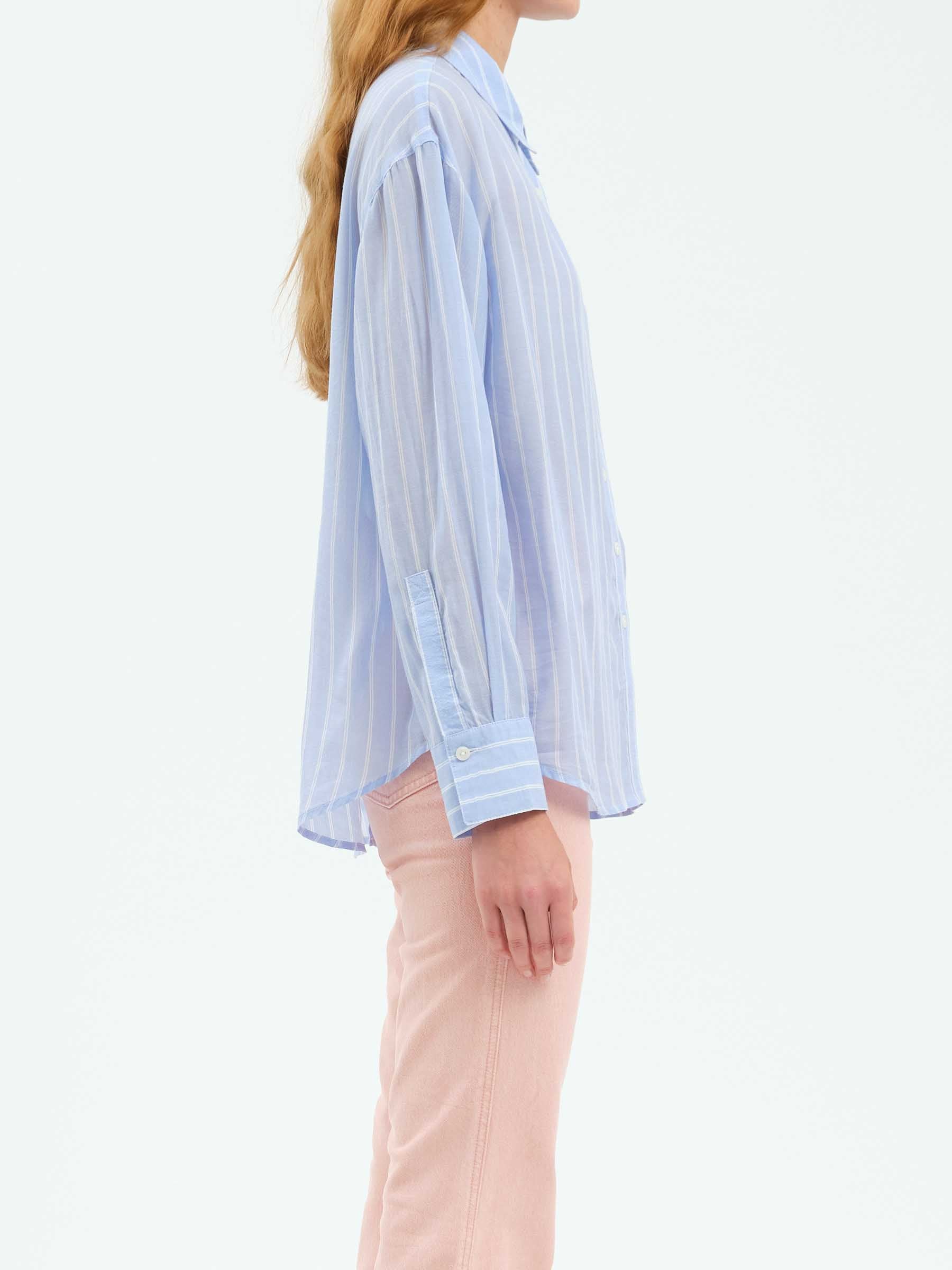 Side profile of the Daze Lotus Back Tie Long Sleeve Shirt, emphasizing the slightly oversized fit and long sleeves with buttoned cuffs.