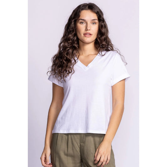 Front view of Pink Martini's 'Dayna Top'. A white V-neck T-shirt with a relaxed fit, rolled sleeves, and breathable fabric, styled with olive pants.