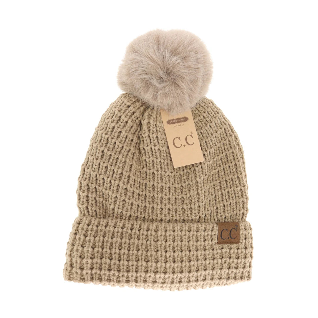 C.C Beanie Knit Pom-Pom Hat in tan, displayed on a clean white background, showcasing the textured knit design and faux fur pom-pom.