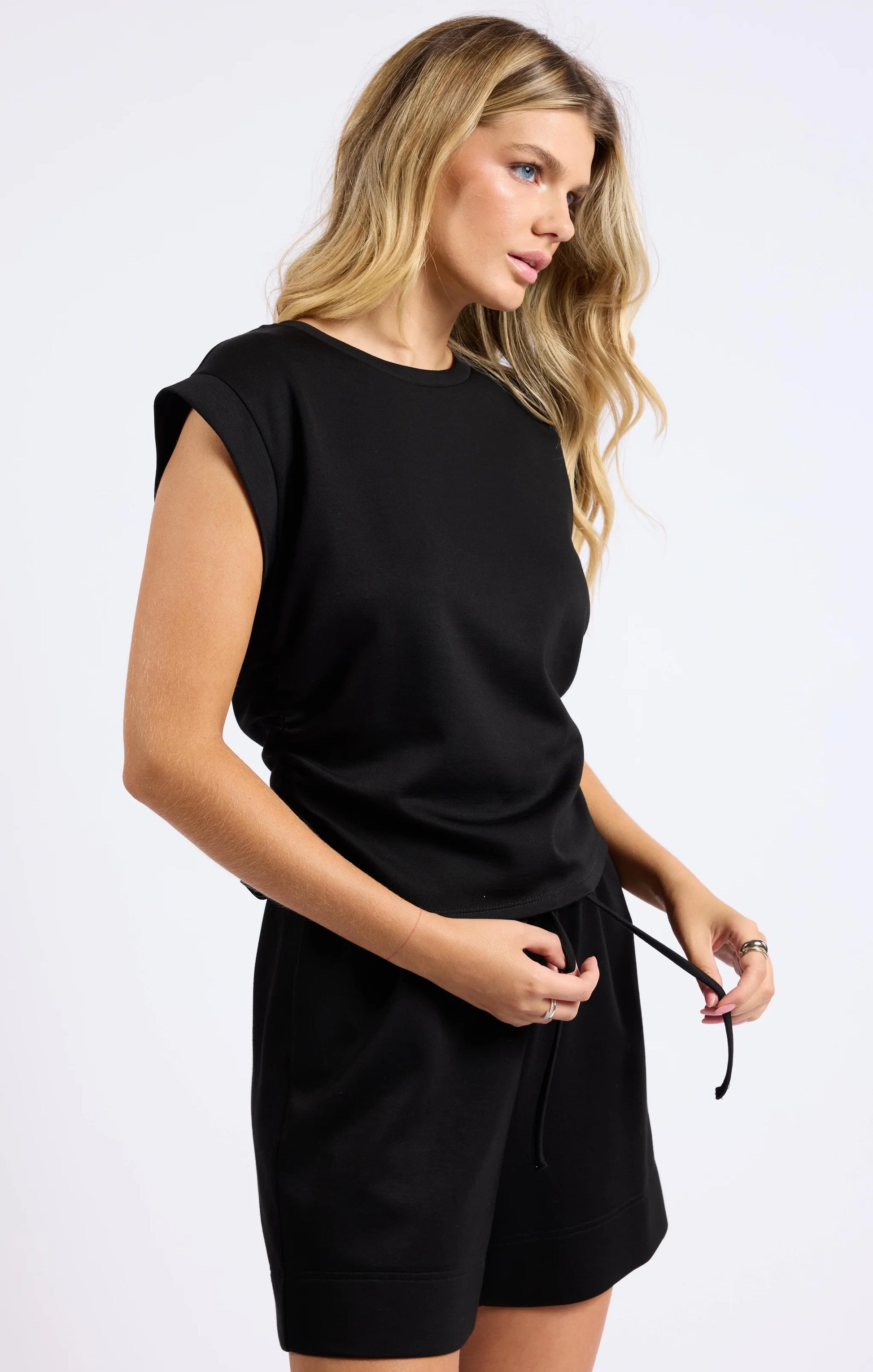 Model looking to the side, emphasizing the drapey silhouette and soft fabric of the All Well Knit Top.