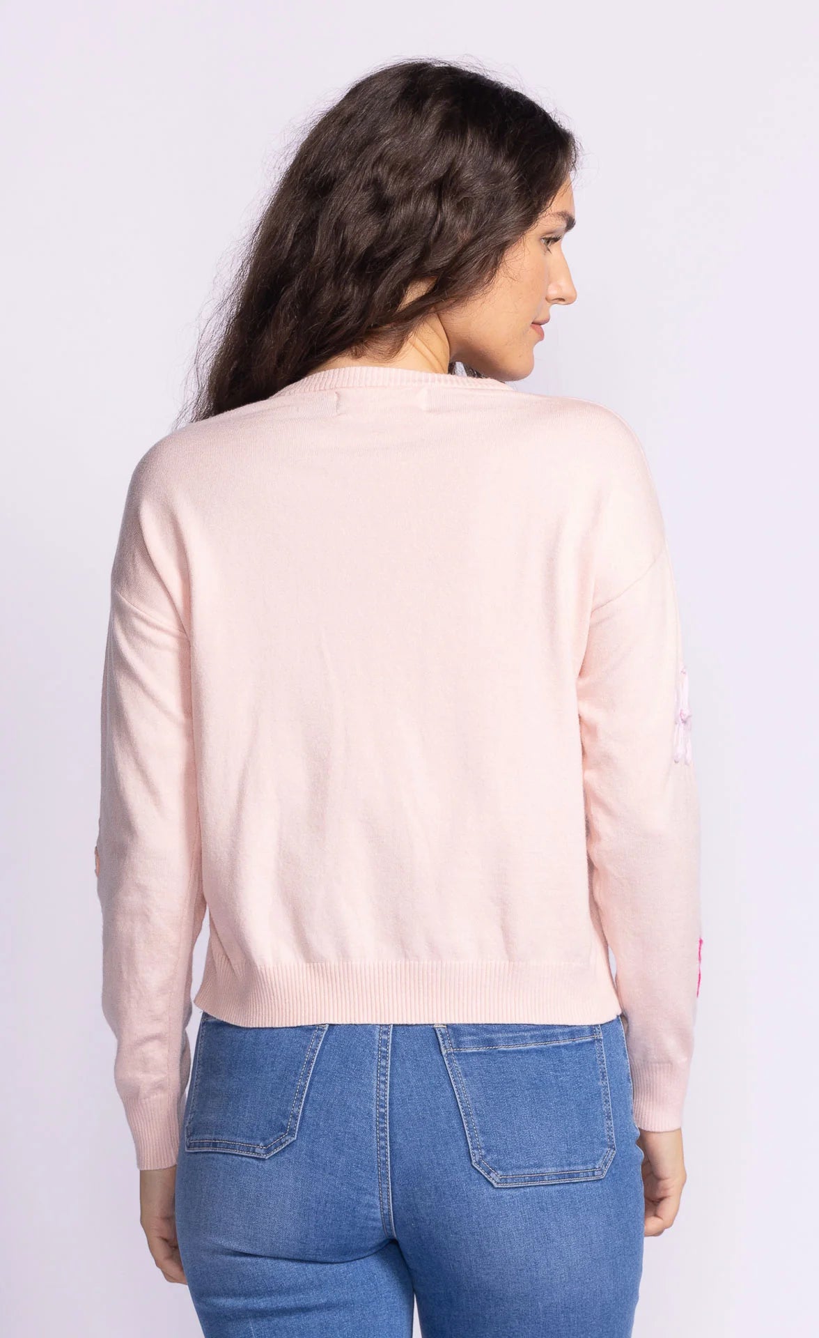 Back view of the Pink Martini Evie Sweater in light pink, highlighting its clean, minimalist design with a smooth knit texture.