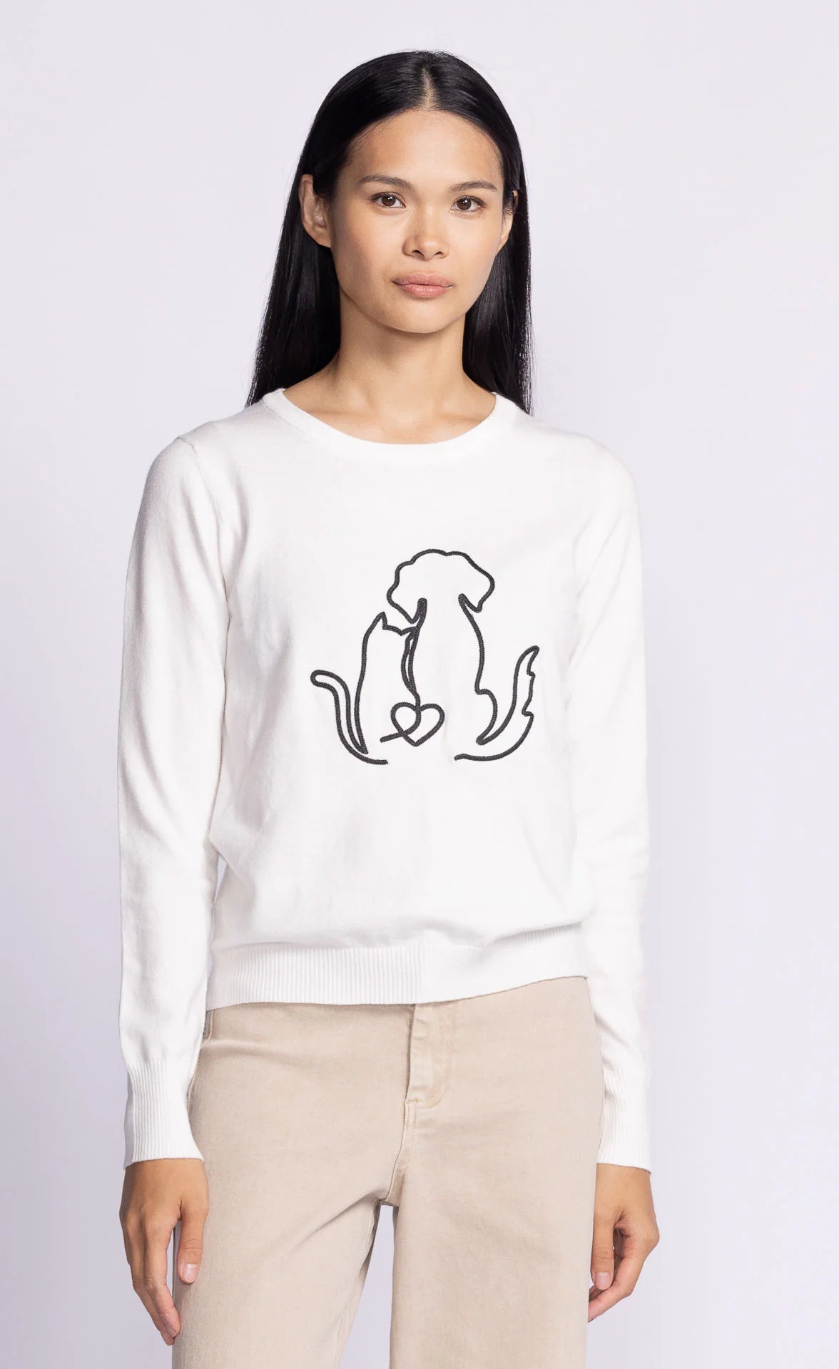 Model wearing the Friends Forever Sweater by Pink Martini, displaying the front embroidery of a puppy and kitten.