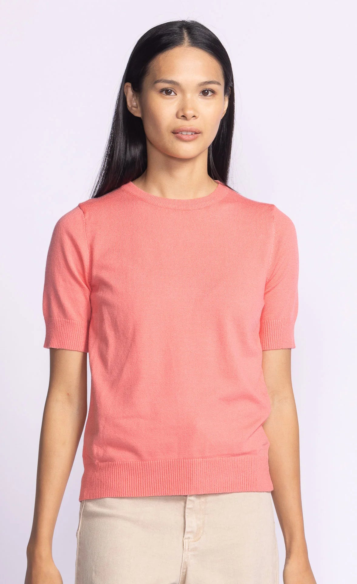 Front view of the Pink Martini Sandy Top in coral, a soft knit short-sleeve top with a round neckline and ribbed hem.