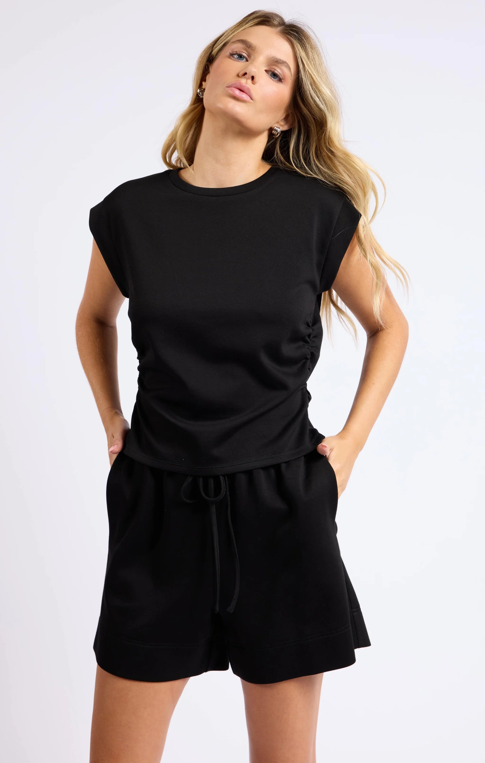 Model facing forward, showing the round neckline and casual yet stylish cut of the knit top.