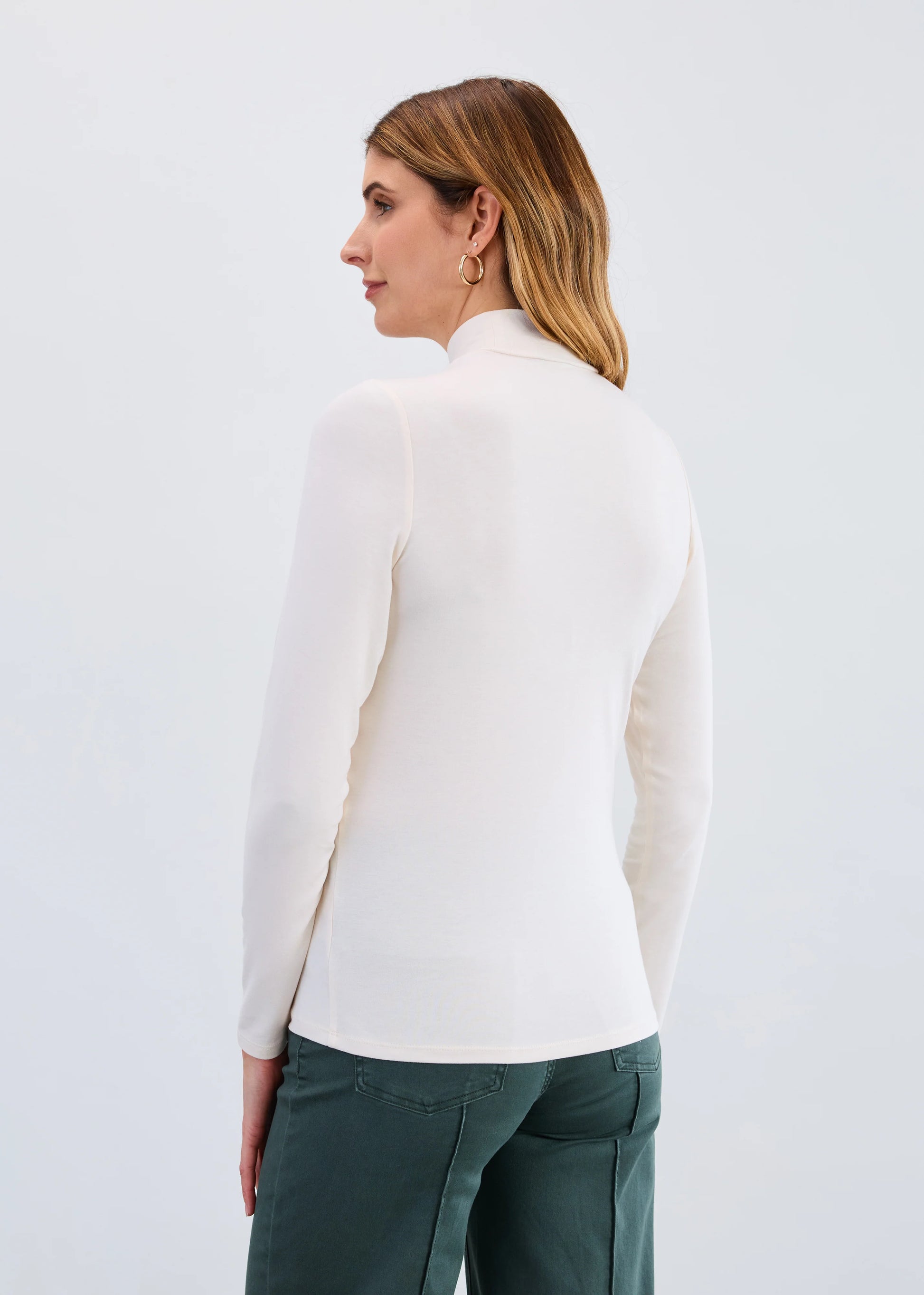 Back view of model in FDJ long sleeve cream mock neck base top, boutique style from Gayle’s Fashions Canada.