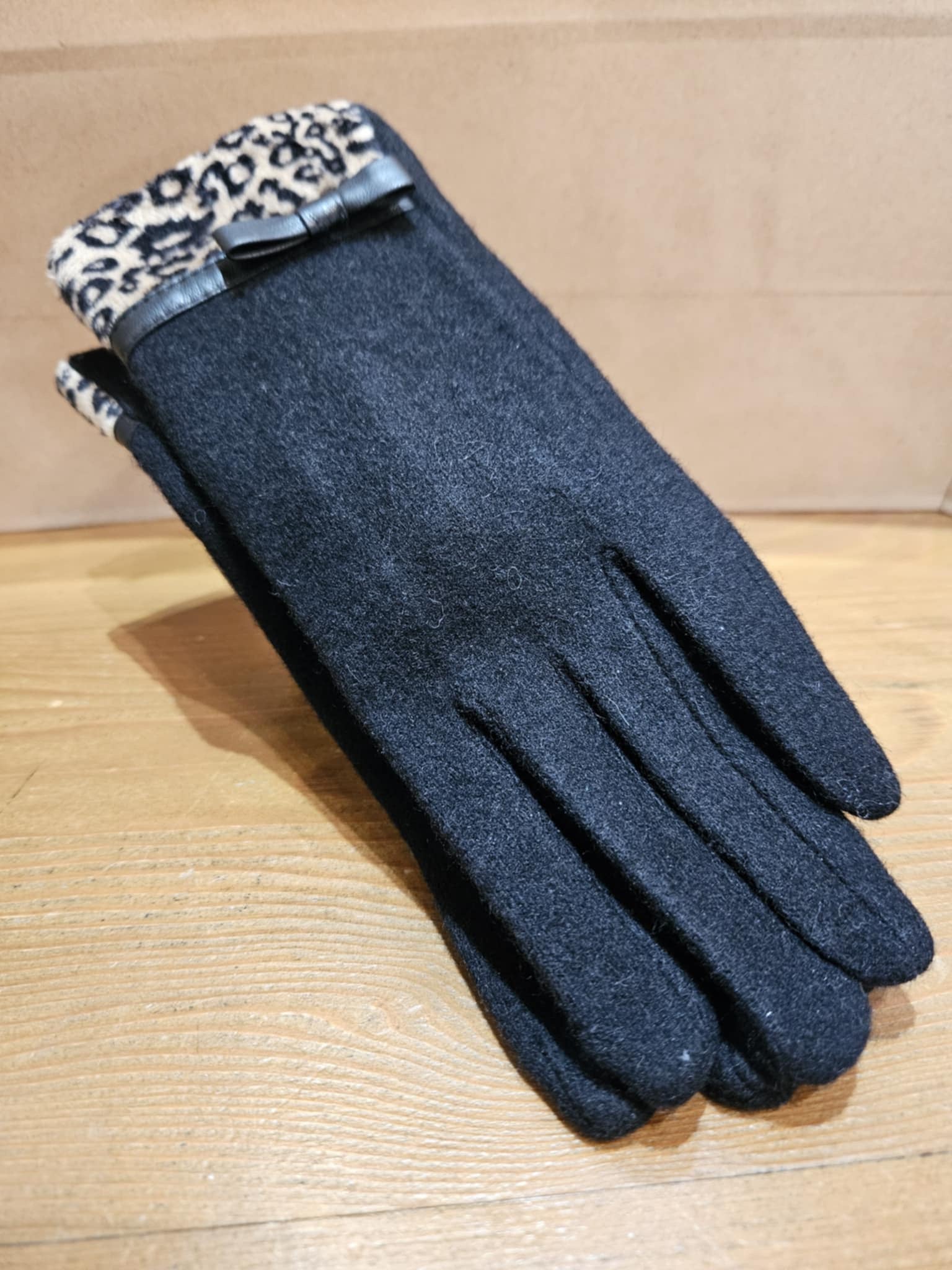 Morgan & Taylor Jacqueline Woollen Gloves styled flat with a black wool base and eye-catching leopard print detail at the cuff.