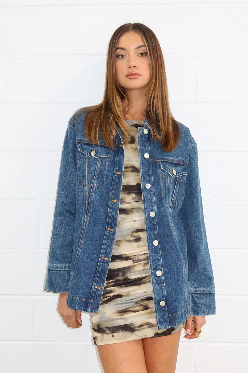 Madison the Label's "Alba Denim Shirt. A classic oversized denim shirt/jacket. Front button closure. A wardrobe staple for all seasons. A medium-darker wash denim. Two front breast pockets.