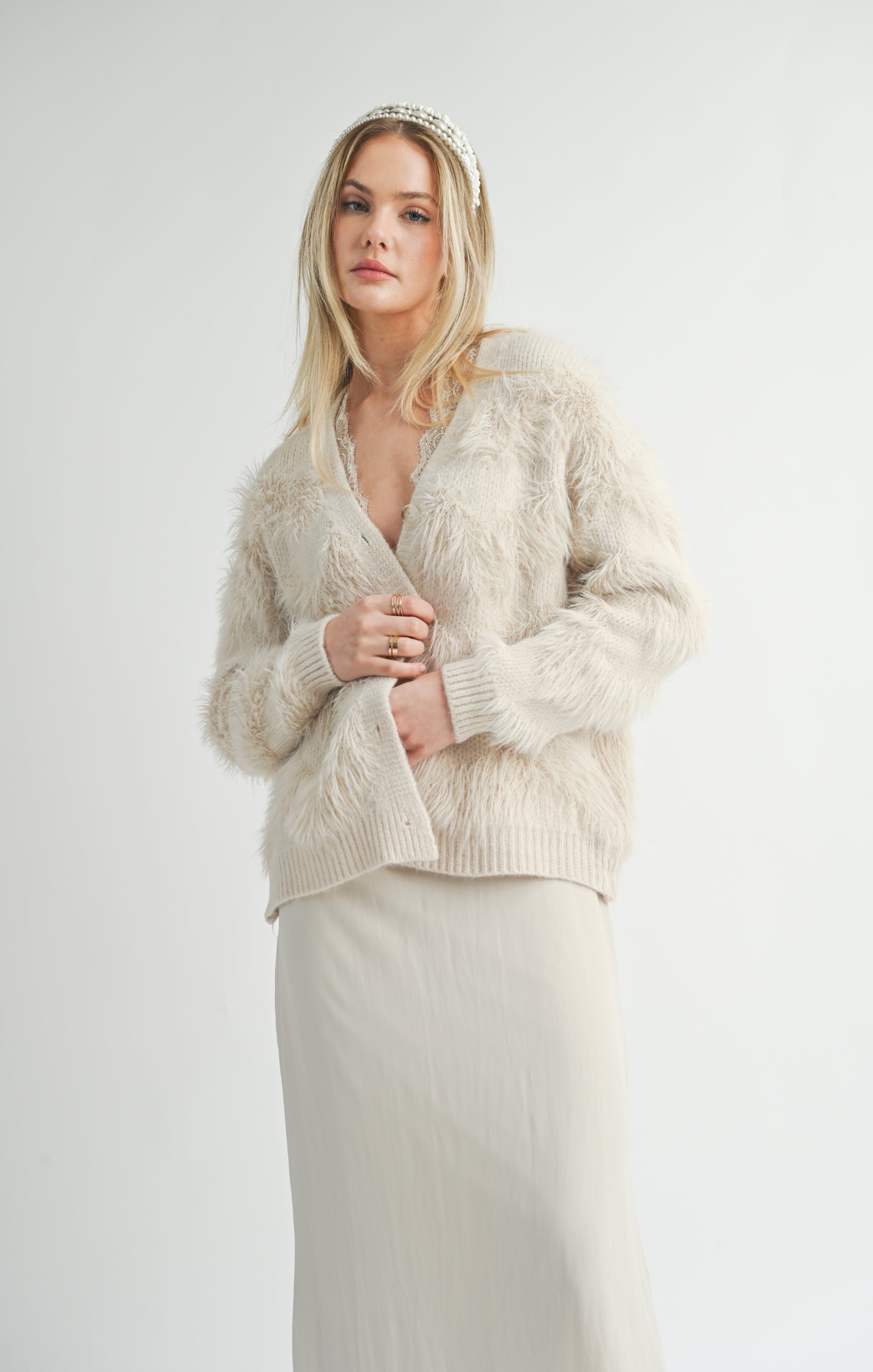 A lovely regular-length cardigan. This cozy cardigan feathers a feathered outer texture in an ivory color. A perfect year-round wardrobe stable!